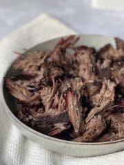 Mouth watering pulled smoked chuck roast in a off white bowl.